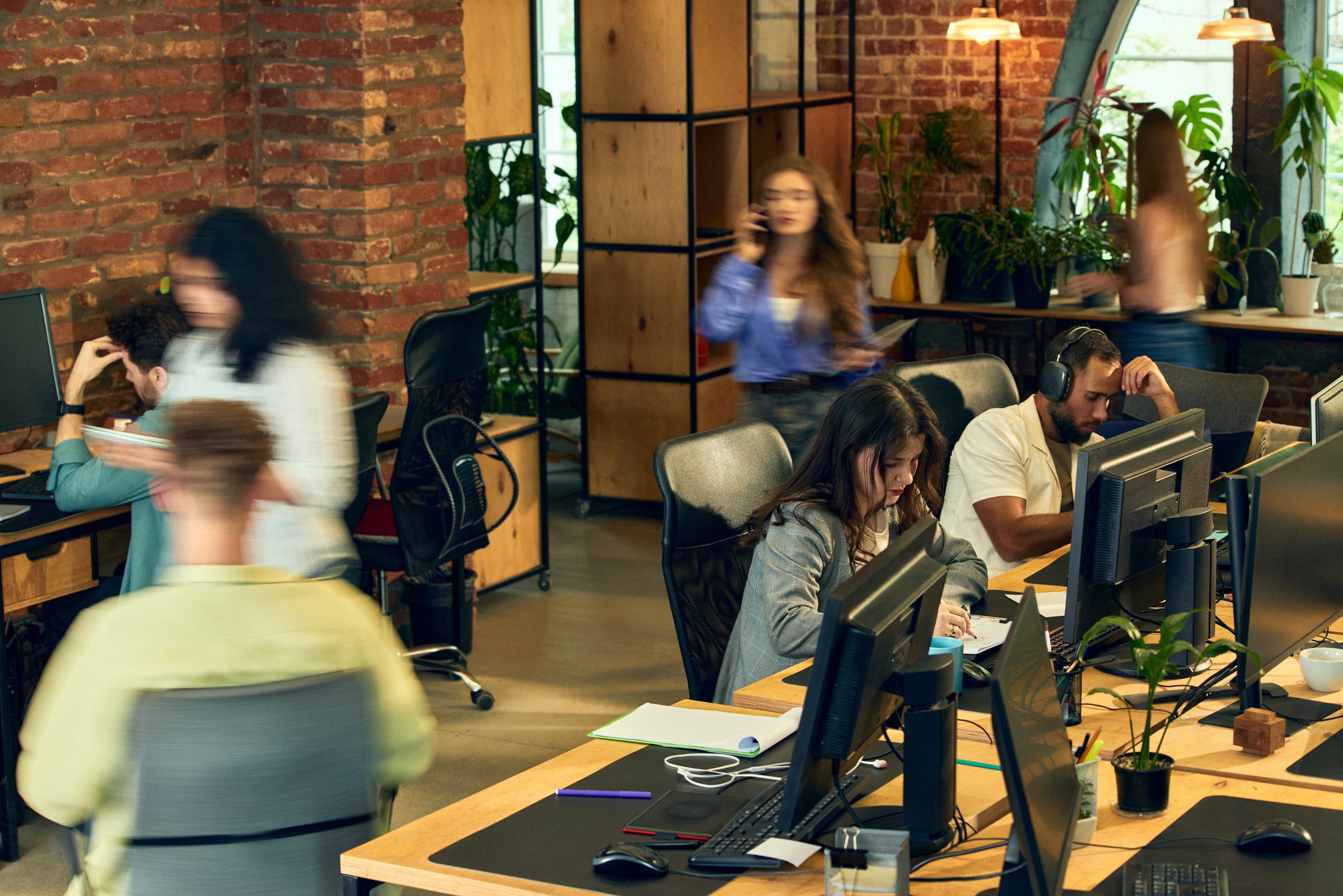 Employees experiencing change balancing focused work with constant office movement in dynamic creative workspace